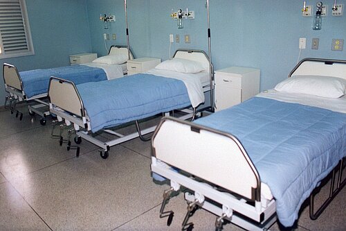 A hospital ward with three beds.