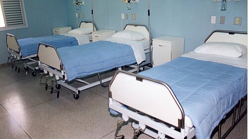 A hospital ward with three beds.